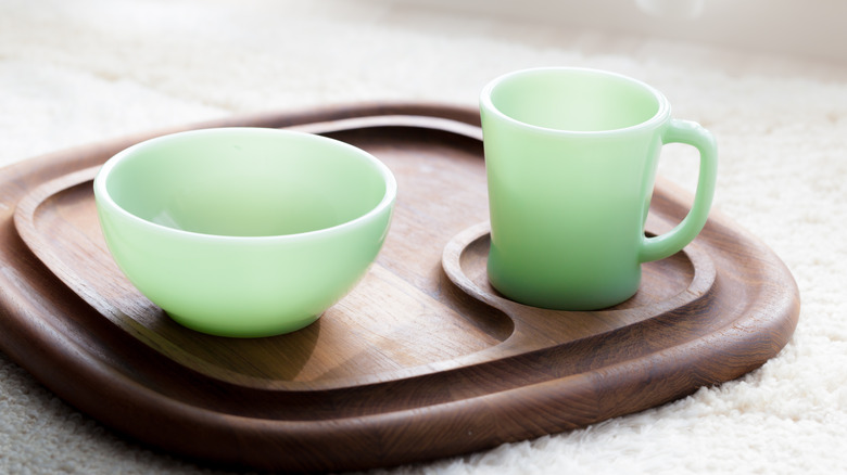 Closeup of jadeite bowl and mug glassware on a wooden board