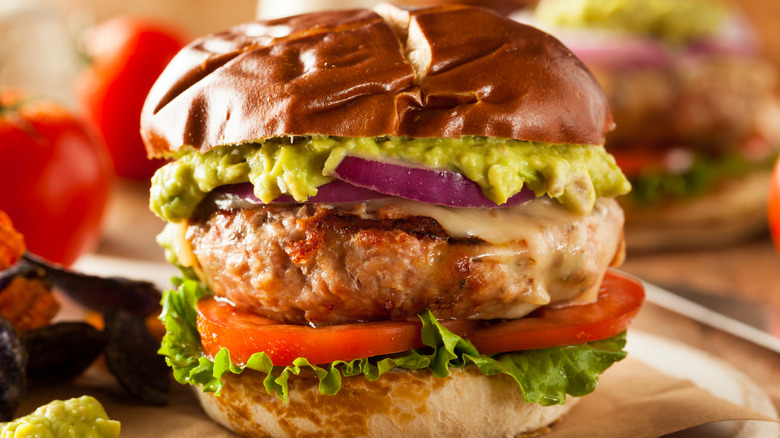 A turkey burger laden with toppings on a bun