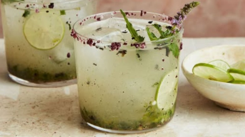 Two margaritas with bowl of lime wheels