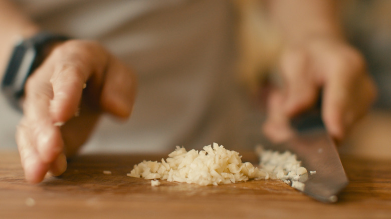 Hands mincing garlic
