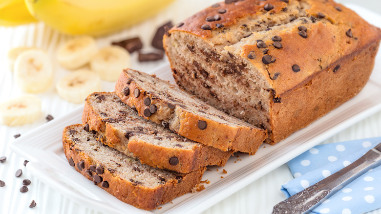 Sliced chocolate chip banana bread on white serving plate