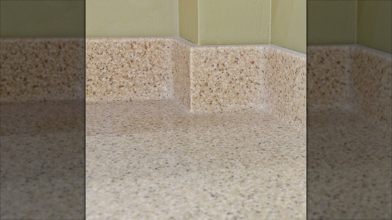 Coved countertop with green wall behind it