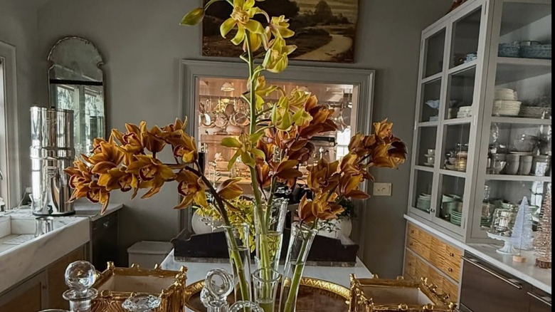 Martha Stewart's servery area filled with glassware, servingware, china, decanters, and orchids