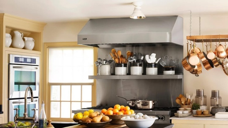 Martha Stewart's farm kitchen with hanging pots and pans near stove