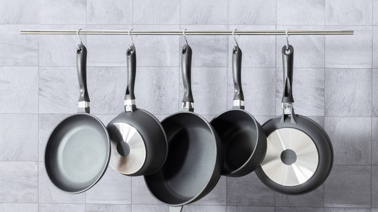 View of pans hanging from a rack in the kitchen