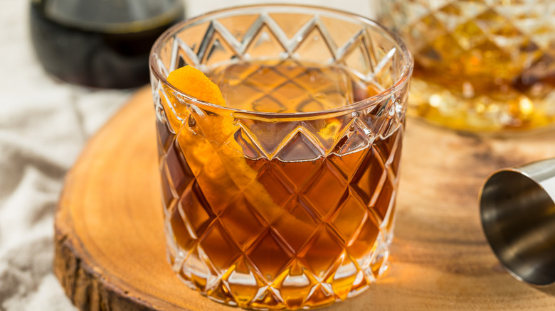 A maple-bourbon cocktail in a crystal tumbler glass