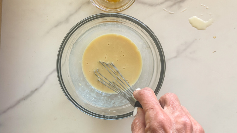 hand stirring sauce with whisk