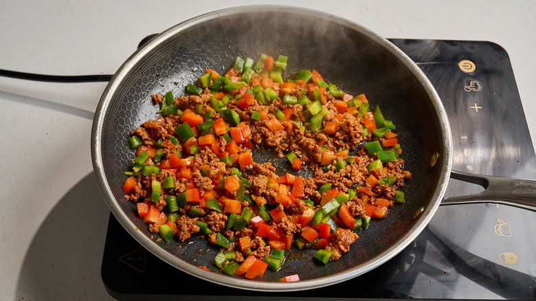 cooking chorizo and peppers in a skillet
