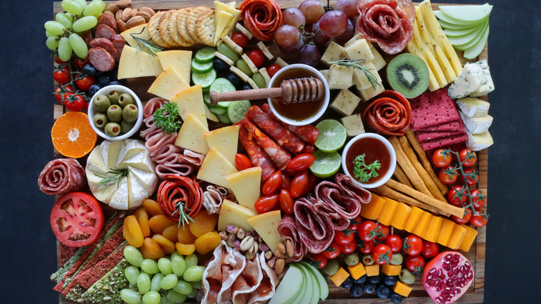 a beautiful display of cheeses, charcuterie, fruits, crudites and condiments
