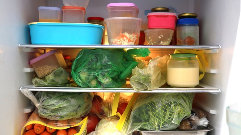 disorganized refrigerator with many items piled in