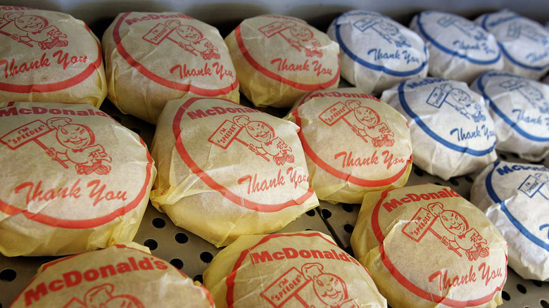 Rows of yellow and white paper-wrapped McDonald's hamburgers.