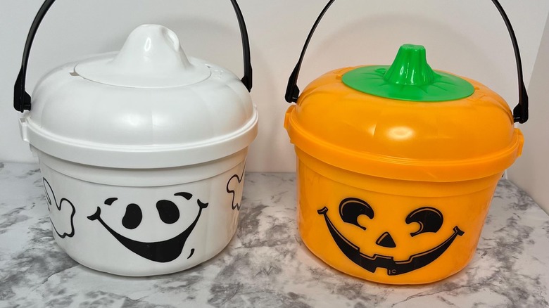 Two McDonald's Boo Buckets in ghost and pumpkin designs on marbled surface