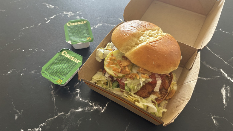 McDonald's McCrispy chicken sandwich next to Caesar sauce packets