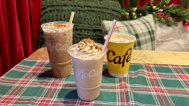 Three McDonald's cookie butter coffee drinks on table with holiday decorations