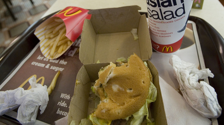 A messy McDonald's table with half-eaten food on it