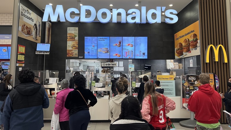 Customers wait in line at a McDonald's counter