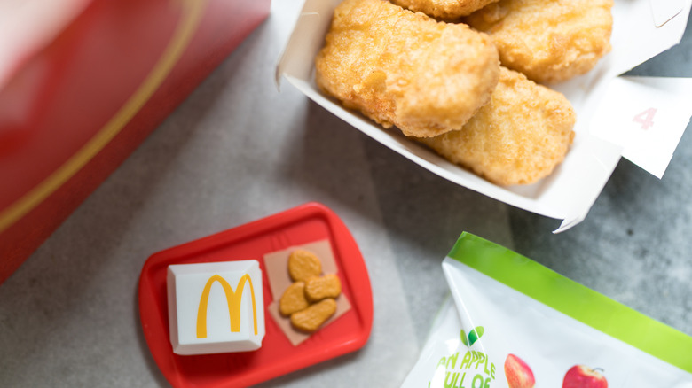 Miniature McDonald's toy tray on a table beside a regular box of Chicken McNuggets