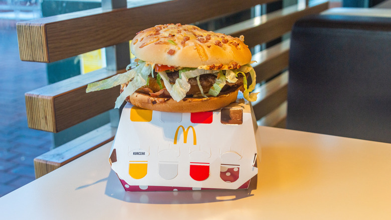 A giant McDonald's hamburger sitting on top of its box on a restaurant table