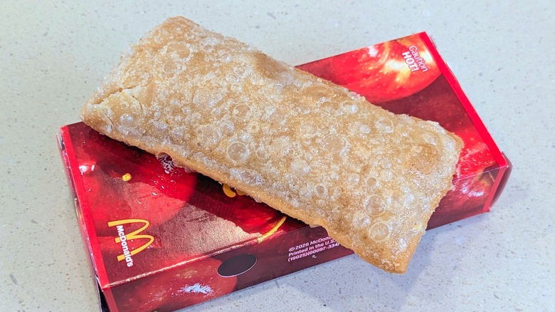 A Fried Apple Pie from McDonald's balanced on the box it came in