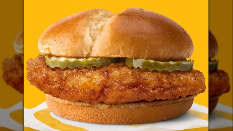 The regular McDonald's McCrispy sandwich with pickles on yellow background