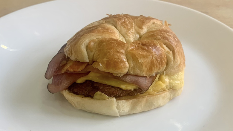 Loaded Croissan'wich on white plate with wood background