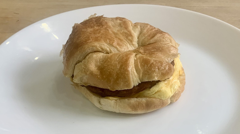 Sausage Croissan'wich on white plate with wood background