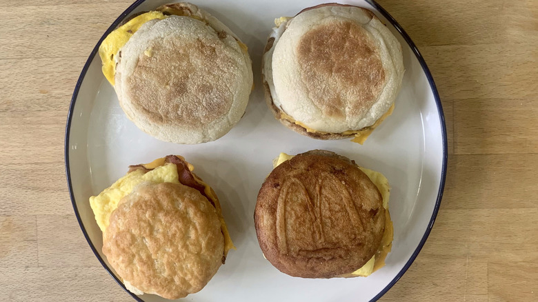 Four McDonalds breakfast sandwiches on a plate on wood background