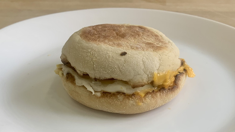 Egg McMuffin on white plate with wood background