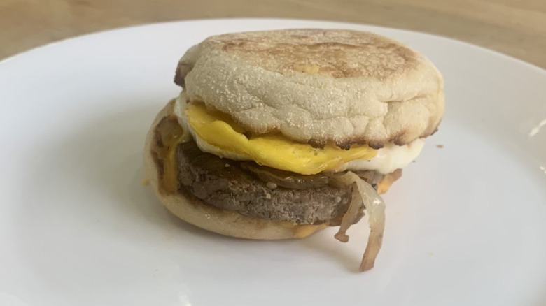 Steak Egg and Cheese McMuffin on white plate with wood background