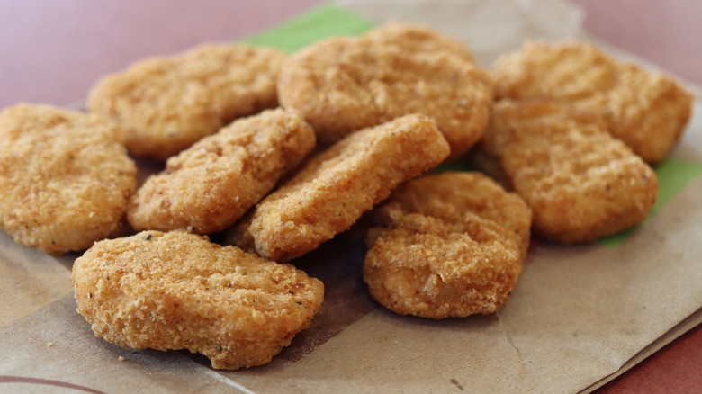Close-up view of a pile of chicken nuggets, one of which is sliced in half