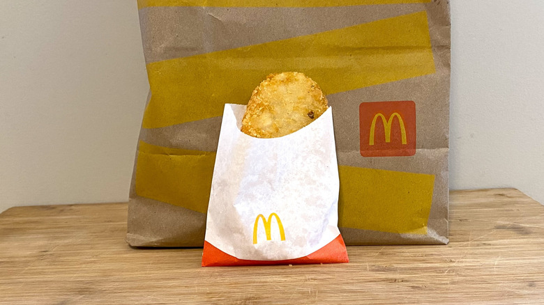 Hash Browns leaning against a McDonalds bag.