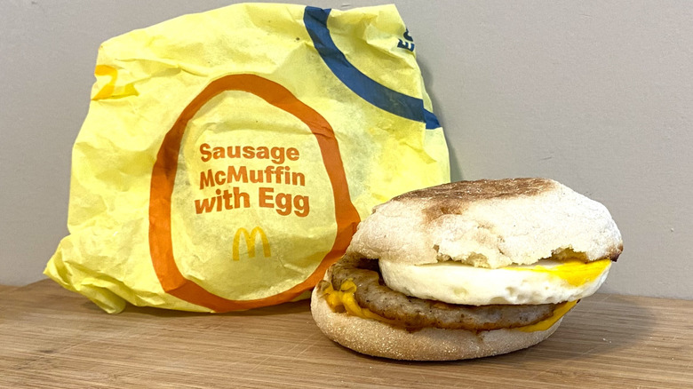 Sausage McMuffin with Egg next to a McDonalds wrapper.
