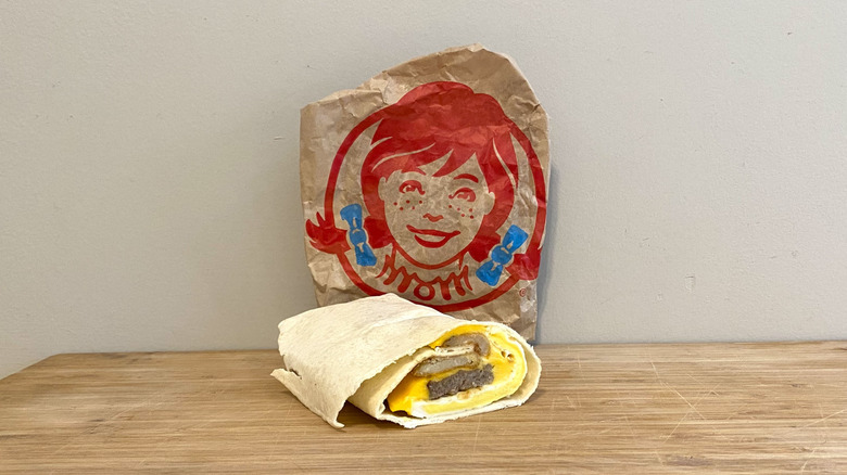 Breakfast Burrito with Sausage in front of a Wendy's wrapper.