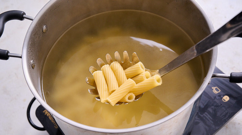 pulling pasta out of boiling water
