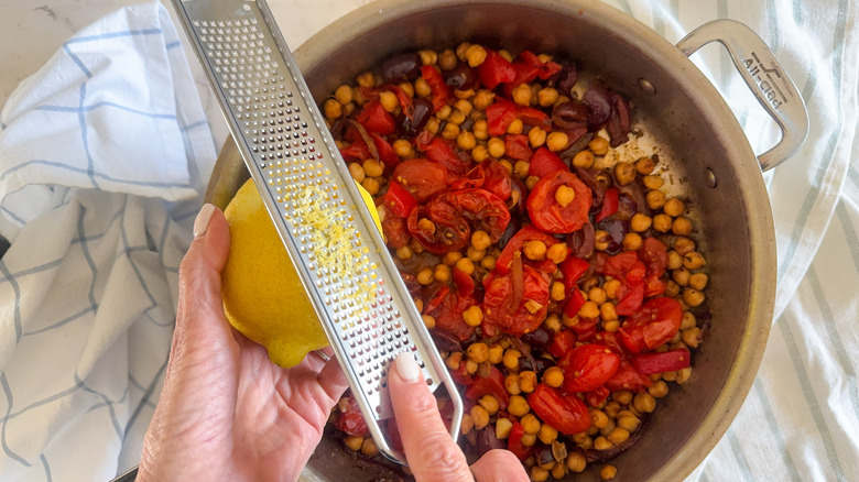 hand adding lemon zest to pan