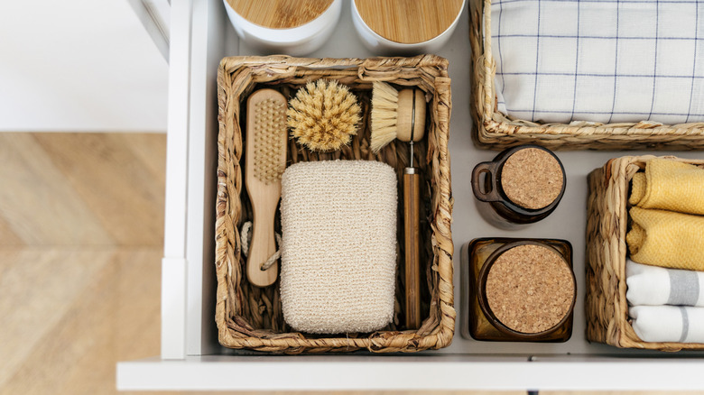 Open drawer in a kitchen cabinet with wicker baskets