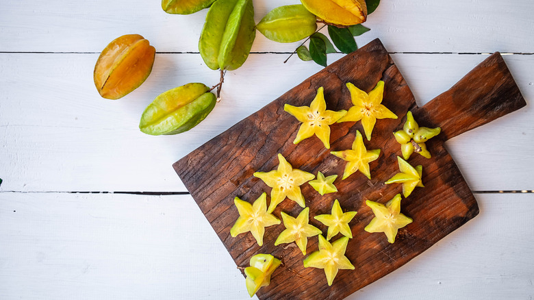 Star fruits pieces on wooden cutting board