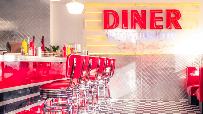 A retro-style Rock Ola jukebox sits on a table with condiments at a Mel's Diner