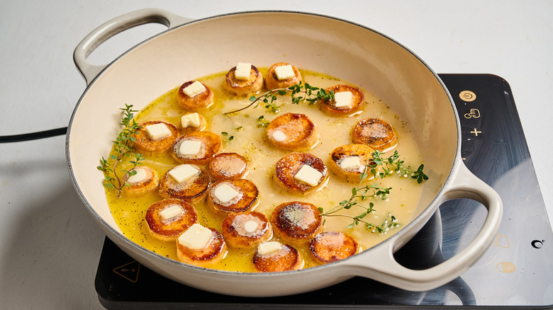 butter added to each potato in the pan
