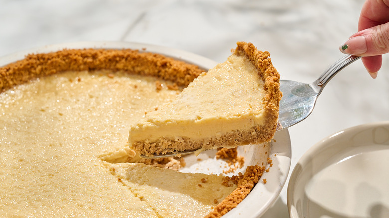 lifting slice of mexican cheese pie out of pie pan