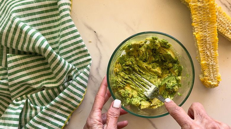 hand mashing avocado