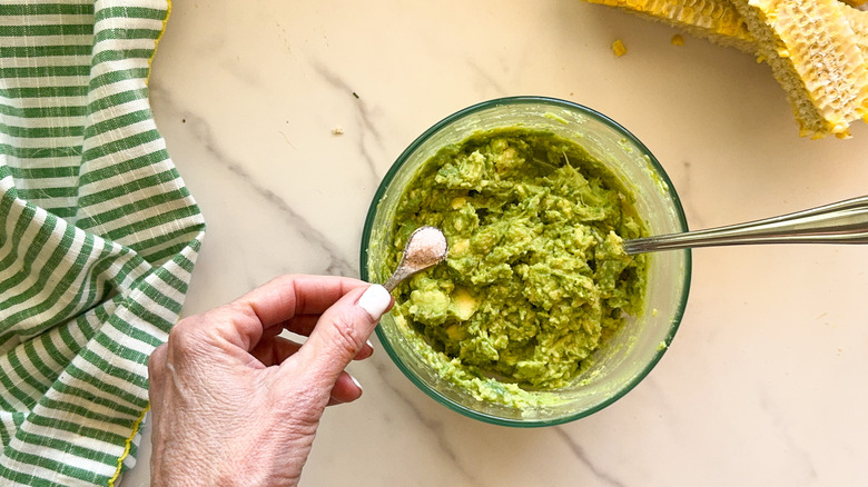 hand adding salt to bowl
