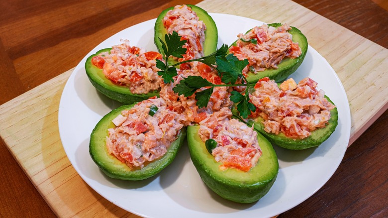 Mexican tuna salad in six avocado boats arranged like a flower with cilantro garnish on top
