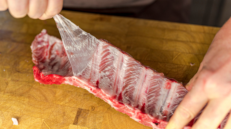 Pulling silver skin off uncooked ribs