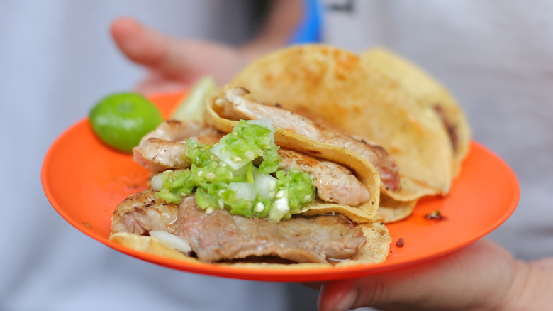 Tacos at El Califa de León on a red plate