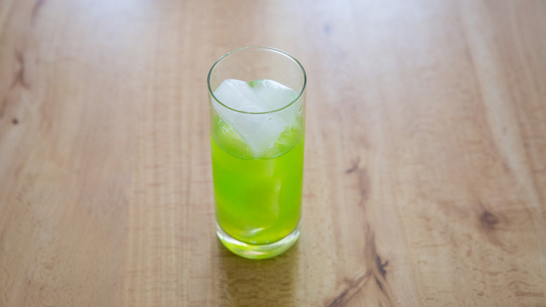 green cocktail on wooden table