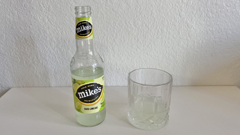 Mike's Hard Limeade bottle on a table next to a glass