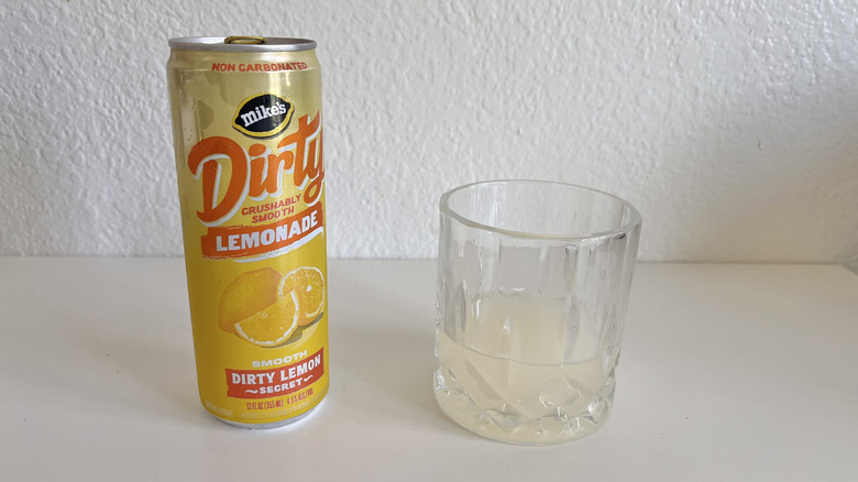 Dirty Lemonade Dirty Lemon Secret can on a table next to a glass