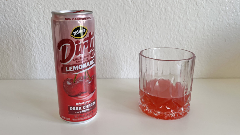Can of Dirty Lemonade Dark Cherry Brew on a table next to a glass