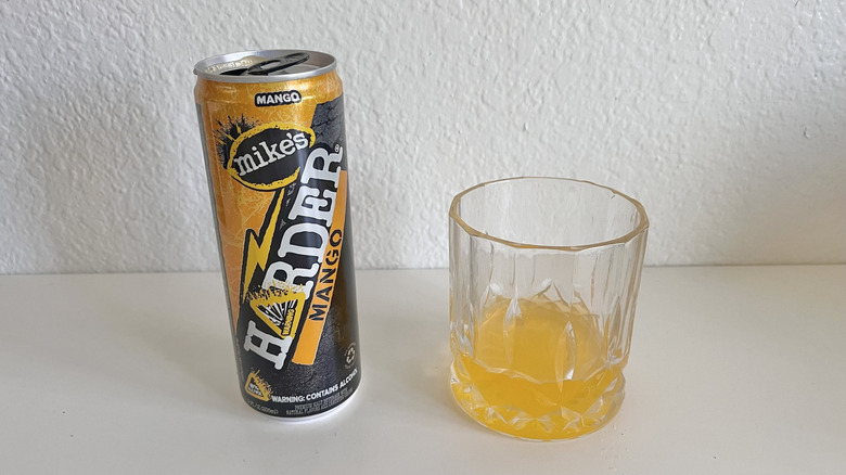 Harder Mango can on a table next to a glass